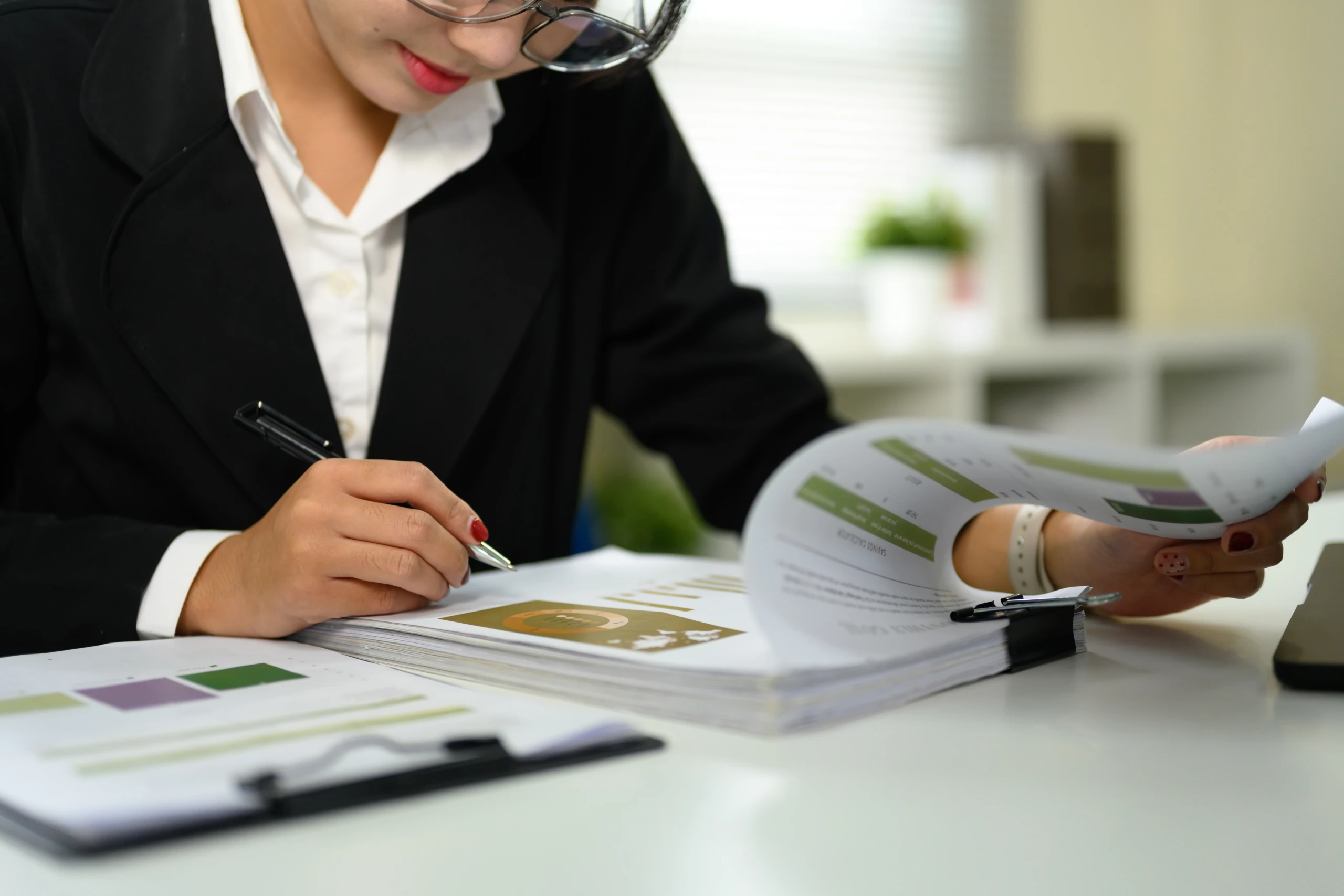 Vérification d'une liasse fiscale, stylo à la main, documents et calculatrice